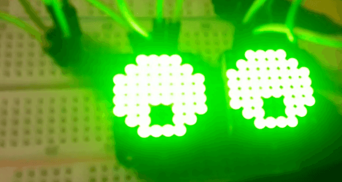 "two led matrices with green lights illustrating eyes"